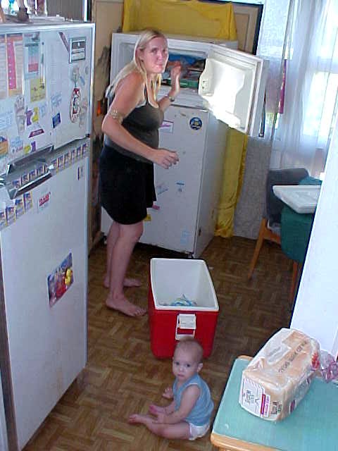 Storm plays on the kitchen floor as Sue fills up the second fridge in the house.