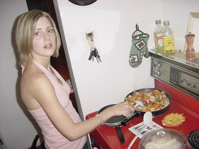 Hayley is preparing a pan full of a stir fry with scallops and rice for dinner.