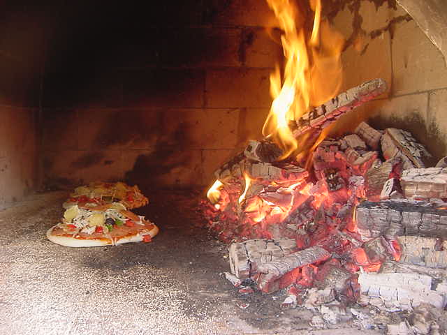 Inside of this hole is the wood and the pizzas are actually baken next to the really hot fire. And as a professional Italian Richard swept out the delicious looking pizza when it was ready. 